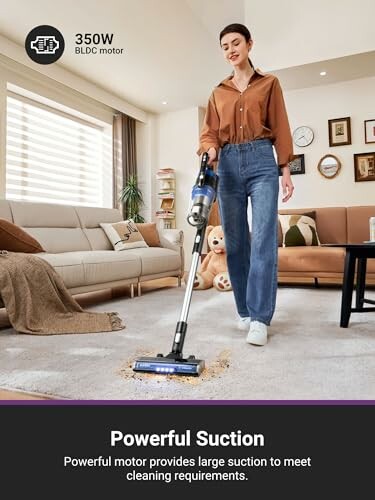 Person using a cordless vacuum cleaner on a carpet in a living room.