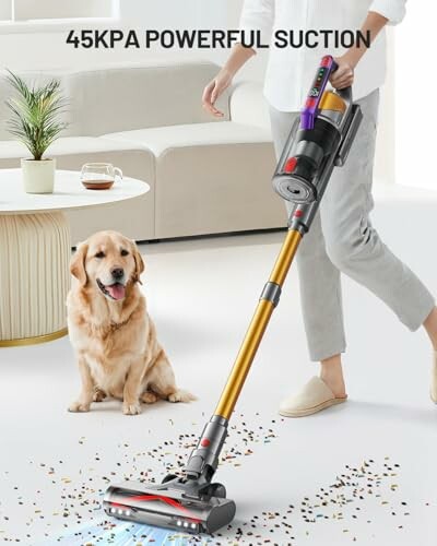Person using a cordless vacuum cleaner with a dog nearby.