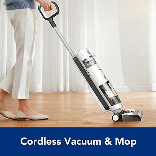 Person using cordless vacuum and mop on wooden floor