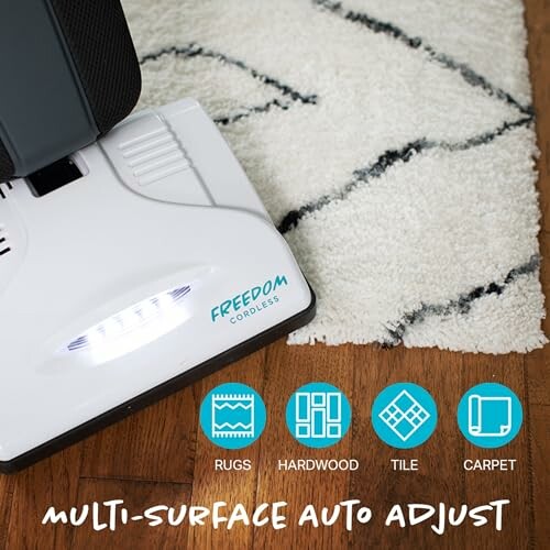Cordless vacuum on rug with multi-surface auto adjust feature.