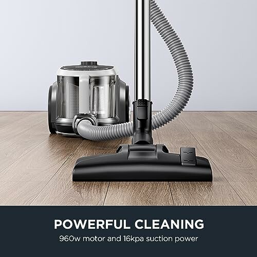 Vacuum cleaner with powerful 960w motor and 16kpa suction on wooden floor.