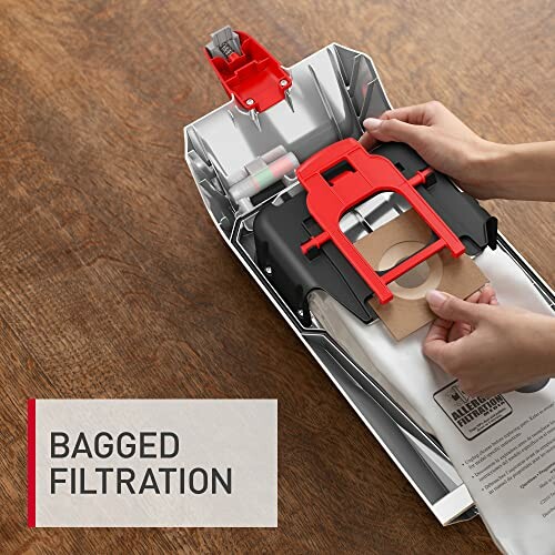Person installing a bag in a vacuum cleaner with 'Bagged Filtration' text.