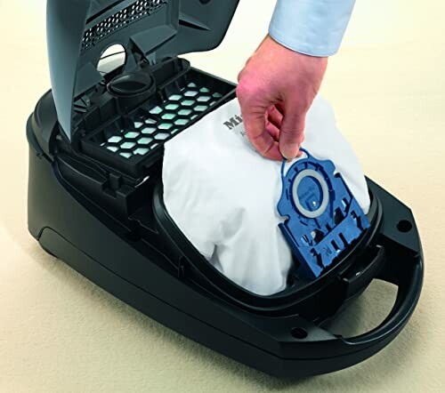 Person replacing a vacuum cleaner bag