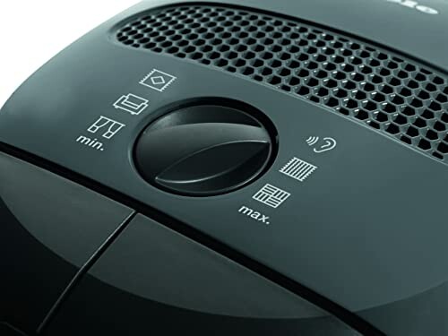Close-up of a vacuum cleaner control panel with settings knob and icons