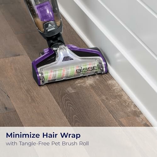 Vacuum cleaner with tangle-free pet brush roll on wooden floor.
