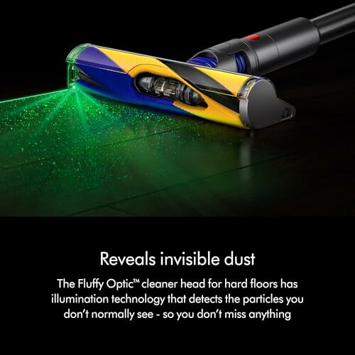 Vacuum cleaner head with green illumination revealing dust on hard floor.