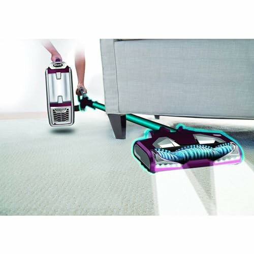 Vacuum cleaner being used under a couch