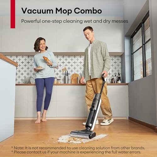 Man using a vacuum mop combo on a kitchen floor while a woman watches.