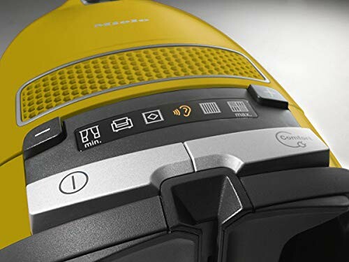 Close-up of yellow vacuum cleaner controls and buttons.