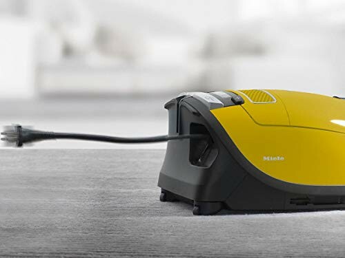 Yellow vacuum cleaner with retracted power cord.